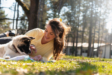 Naklejka na ściany i meble Beautiful female playing with her dog outdoor