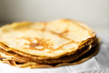 pancakes on a white tablecloth and plate a sunny day with sun glare