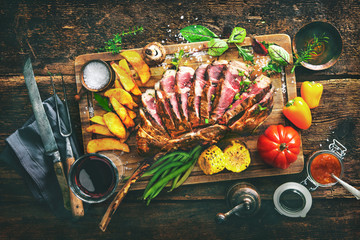 Grilled meat, sliced ​​tomahawk beef steak with spices, french fries and vegetables