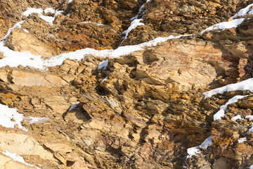A piece of rock under the bright sun. Winter stones on the wall of the mountain. Just stones close to plan.