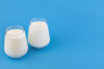 Organic probiotic kefir or yogurt with probiotics in glasses on blue background. Homemade cold fermented dairy drink. 