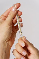 Close up of female hands with a thermometer