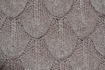 Knitted texture with patterns in light brown. Background template for the design of the banner, site, card, wallpaper, textile canvas. Fashionable concept. High quality photo
