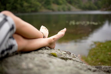 girl relaxing barefoot by lake