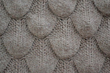 Knitted texture with patterns in light brown. Background template for the design of the banner, site, card, wallpaper, textile canvas. Fashionable concept. High quality photo