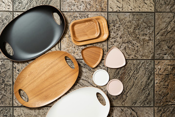 Wooden tray and plate on tile background 
