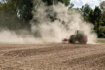 Symbolbild für Dürre und Wassermangel, Landwirt wirbelt mit Traktor Staub auf