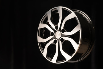 New alloy wheel of the car, close-up on a black background, wheel elements, two-color coating, shiny. the right location on the layout