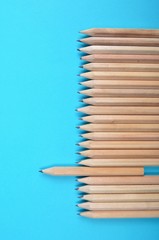 Fototapeta premium Lot of wooden pencils on blue paper background