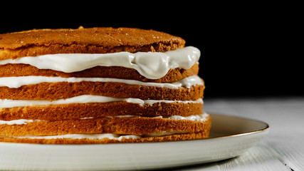 biscuits cake with white cream. 
a lot of cream on the cake. white plate black background. closeup