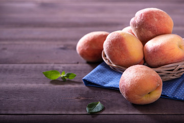 bowl with some peaches  on wooden table