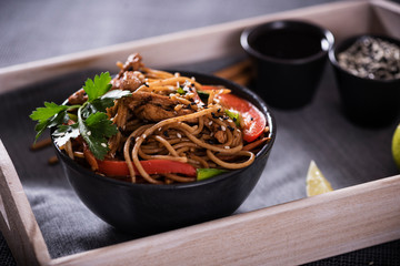 Japanese dish buckwheat noodles soba with chicken and vegetables carrots, bell peppers, mushrooms, green onions