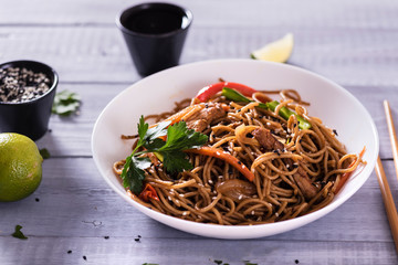 Japanese dish buckwheat noodles soba with chicken and vegetables carrots, bell peppers, mushrooms, green onions