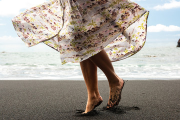 Side of woman turning with dress on beach