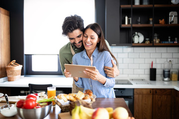 Beautiful couple in the kitchen while cooking.