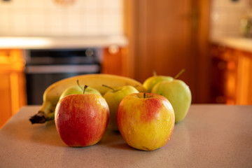 apples and bananas on the kitchen counter in the background oven and door