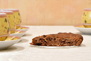 Homemade pie with berries and cups with saucers on the table