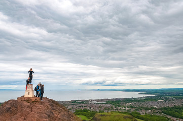 Obraz premium Unrecognizable tourists observing the panorama of Edinburgh from Arthur's Seat