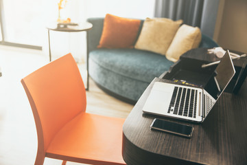 Working desk with computer laptop and smartphone at home office in living room. WFH concept