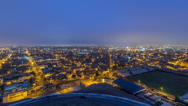 Panoramic skyline of Lima city from above with many buildings aerial night to day transition timelapse from hill. Poor houses with hills on a background. Traffic on streets. Lima, Peru