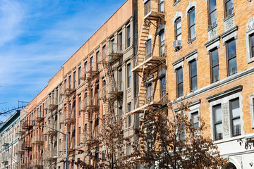 Fototapeta premium Row of Old Buildings with Fire Escapes in Harlem of New York City