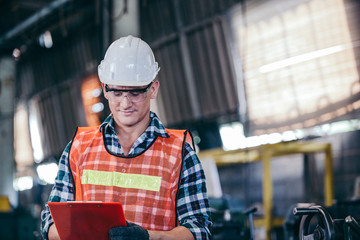 Engineering or technician man worker in hard hat and protective uniform working with document in manufacturing industrial factory. smart manager or leader checking on construction repair checklist
