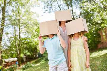 Family stands anonymously with faces under cardboard boxes