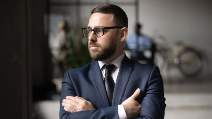 Fototapeta premium Serious Caucasian businessman in glasses look in distance thinking or visualizing, thoughtful middle-aged male boss lost in thoughts pondering over problem solution, plan, business vision concept