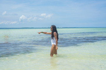 Young indian woman pointing sea in the beach