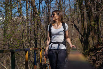 A woman walks in the wood during a sunny day