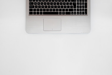 Silver laptop in white background with copy blank space. Top view, flat lay, business workspace