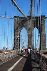 New York City (Manhattan)/ USA-6th September 2010: A picture of a Brooklyn Bridge from a tourist's point of view who through the many iron wire that pulls the bridge to stay and seeing the USA flag