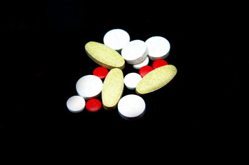 pills on a black background. a bunch of pills. different pills.