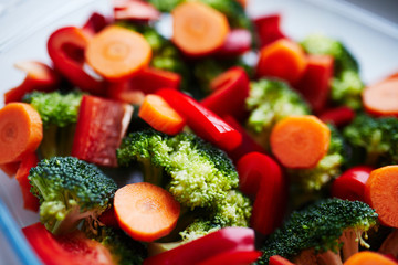 A mix of broccoli, bell pepper (paprika) and round slices of carrot. Bright and colorful close up picture of diet recipe.