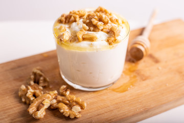 White yogurt cup with honey and nuts. Idea for a healthy and nutritious snack, low in fat.