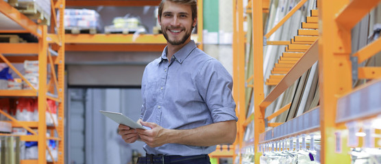 portrait of a smiling young warehouse worker working in a cash and carry wholesale store.