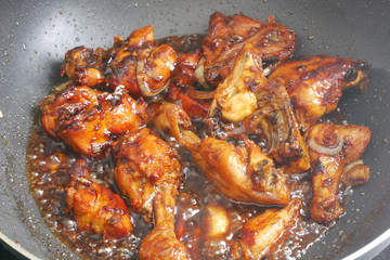 Fried chicken cooked with black soy sauce. The chicken pieces are fried over dry and then poured with soy sauce and onion.