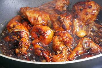 Fried chicken cooked with black soy sauce. The chicken pieces are fried over dry and then poured with soy sauce and onion.