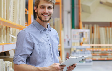 portrait of a smiling young warehouse worker working in a cash and carry wholesale store.