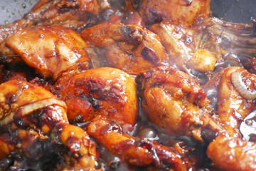 Fried chicken cooked with black soy sauce. The chicken pieces are fried over dry and then poured with soy sauce and onion.