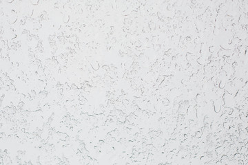 Texture of Frozen drops of condensed steam water drops on the transparent window glass. Clean background. Water vapor condenses on cold window glass and freezes into ice
