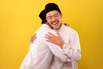 Image of happy two Young Asian Muslim men hugging each other during Eid Mubarak celebration on 1441...
