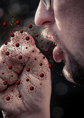 Man coughing into closed fist with virus particles flying out of mouth