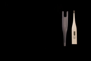 white thermometer with high temperature on a black background isolate