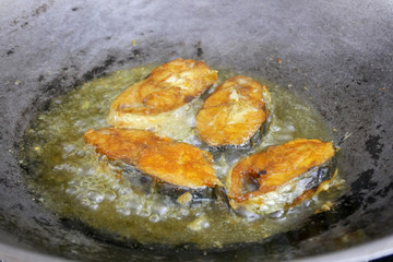 Spanish mackerelsfish cut into thick slices and fried using hot cooking oil. The slices of fish were previously sprinkled with turmeric powder to add flavour.