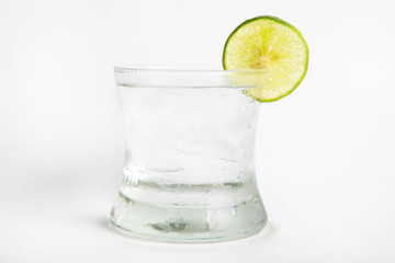 Fototapeta na wymiar gin tonic in a glass decorated by sliced lime white background
