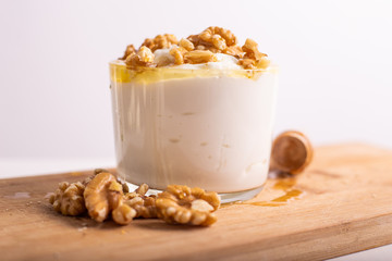 White yogurt cup with honey and nuts. Idea for a healthy and nutritious snack, low in fat.