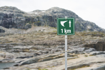 Hiking tourist rout sign to Trolltunga rock with distance, Norway. Last km