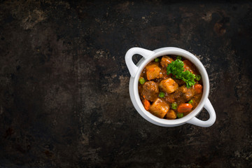 Beef Stew with Potatoes and Carrots on Rustic Metal Background.