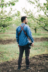 Fototapeta premium Man with a camera in his hands, looks to the side.